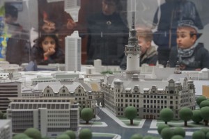 Die Wunderfinder blicken durch eine Glasscheibe auf ein plastisches Modell der Stadt Leipzig mit Uniriesen und Rathausturm