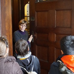 Frau Röhniß öffnet den Kindern eine schwere Holztür